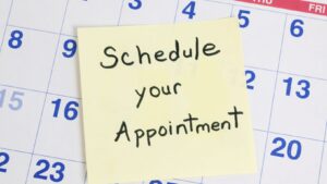 A sticky note on top of a calendar that says schedule your appointment.