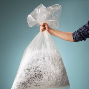 someone holding a bag of shredded paper.