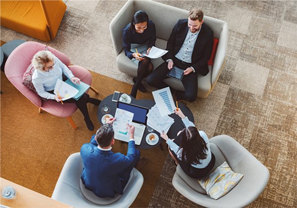 People meeting around a table reviewing documents